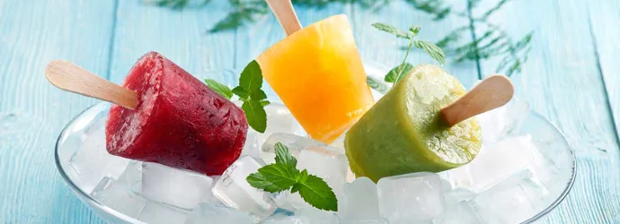 Drie fruitijsjes op een plek bedekt met ijsblokjes