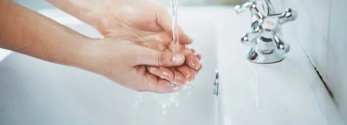 Schone wastafel met koude en warme kranen waarvan kalkaanslag verwijderd is