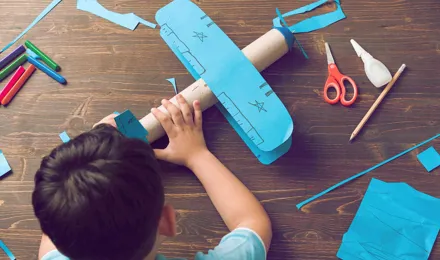 Kind bouwt een doet-het-zelf kartonnen vliegtuigje