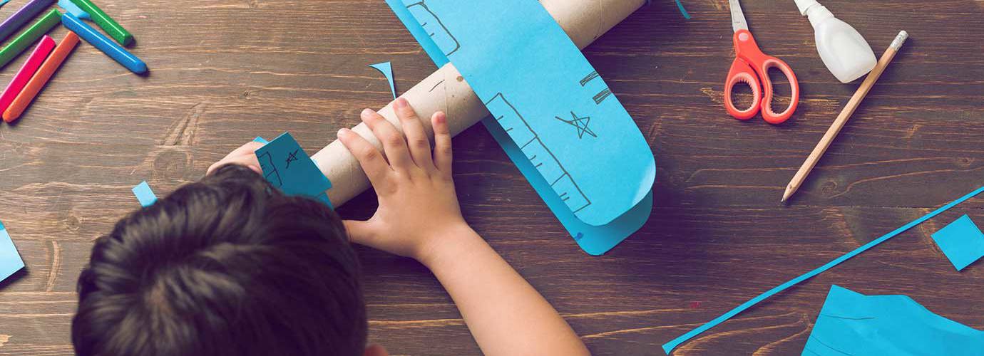 Kind bouwt een doet-het-zelf kartonnen vliegtuigje
