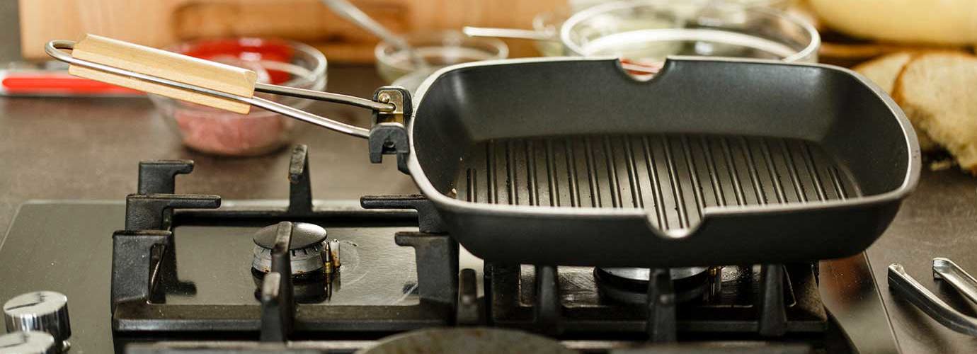 Lege, schone grillplaat op gasfornuis