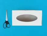 Een lege tissuedoos met een schaar ernaast op een blauwe achtergrond.