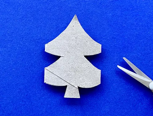Uitgeknipte tekening van de kerstboom, met de uitgeknipte stukken buiten beeld weggegooid.